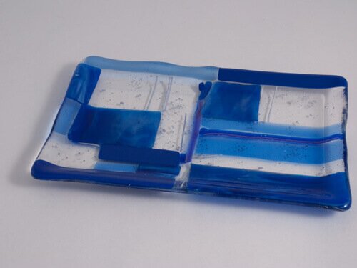A fused glass plate with a blue patchwork pattern